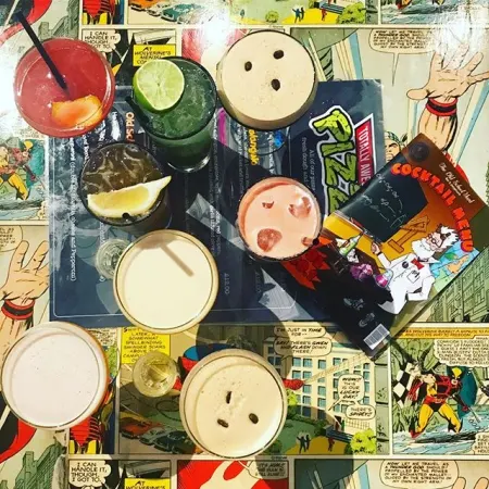 A round of cocktails on the comic-print table