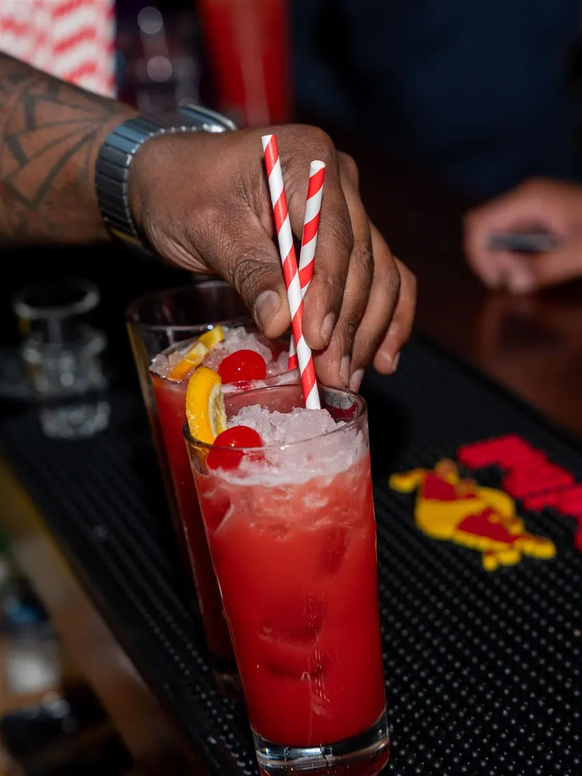 A cocktail being poured behind the bar